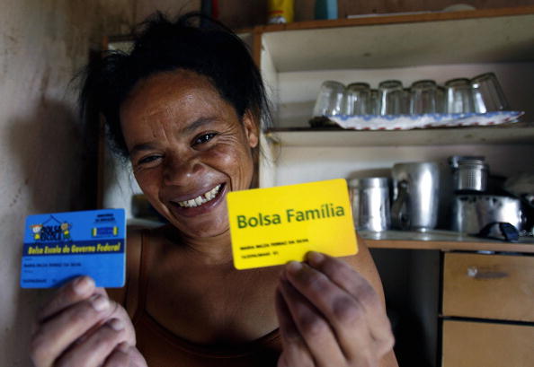 Serra Azul, BRAZIL:  Brazilian Maria Nilza, 36, and mother of four, shows her 'Bolsa Familia' social plan card in Serra Azul, north of the state of Minas Gerais 11 September, 2006. 'Bolsa Familia' was created by Brazilian President Luiz Inacio Lula da Silva in order to help poor people with a monthly pension which ranges from 50 to 95 Brazilian reales (23 to 40 US dollars). For next 01 October election, da Silva advances towards reelection mainly backed by a social programme which meets with the needs of 50 million people.   AFP PHOTO/VANDERLEI ALMEIDA  (Photo credit should read VANDERLEI ALMEIDA/AFP/Getty Images)
